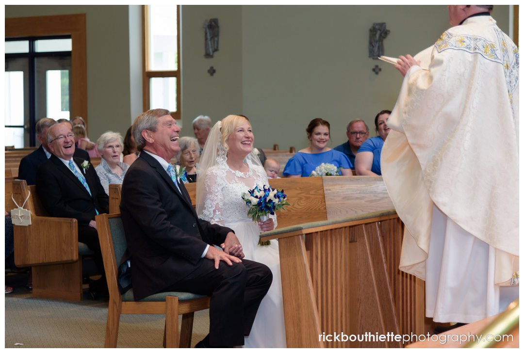 bride and groom seated listening to priest at ceremony at Saint Joseph's Parish
