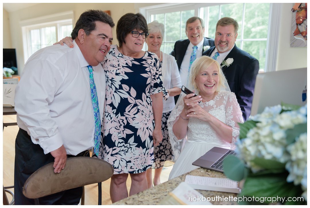 bride, groom and family make skype call to mother of the bride after wedding ceremony 