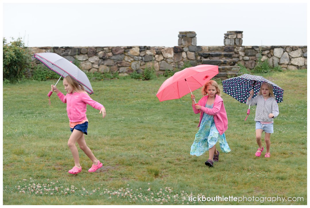 girls running with umbrellas at Ordiorne Point Seacoast wedding reception