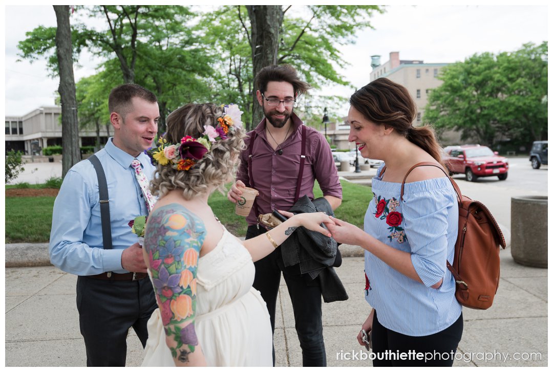 bride & groom meet with friends in front of lowell city hall after wedding
