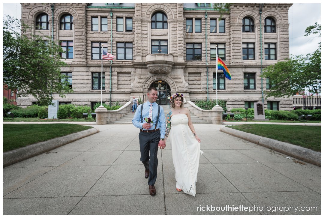 bride & groom walking in front of lowell city hall after wedding